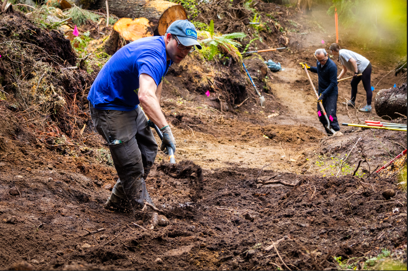 Evergreen trail crew shoveling and shaping sustainable trail tread